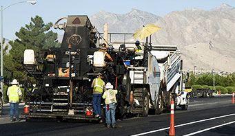 Construction workers asphalt and paving a street