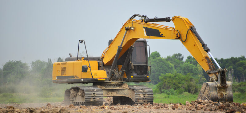 Heavy-duty excavator digging on a large dirt construction site in Conroe, Texas