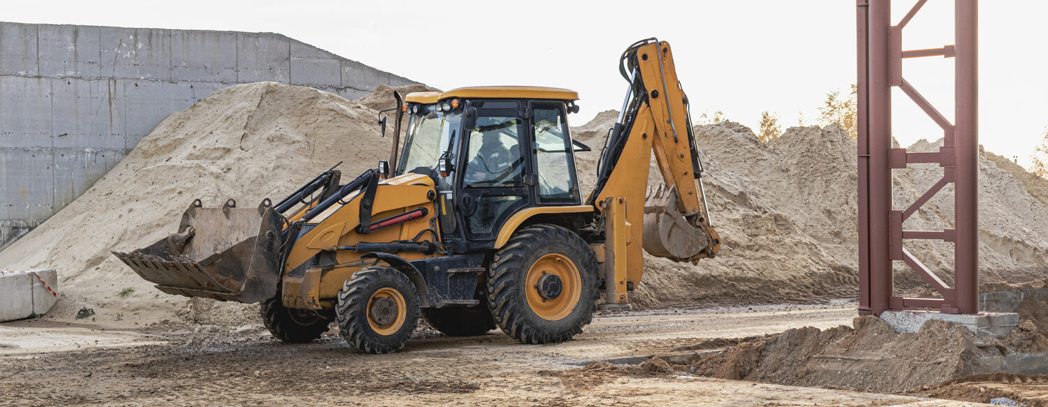 Excavator removing soil for backfilling at a construction site in Sonora, CA